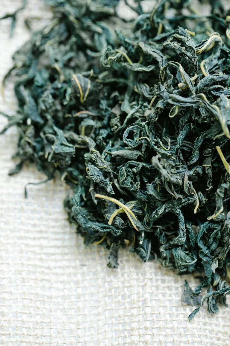Detailed view of dried herbal tea leaves on burlap, perfect for health and wellness themes.